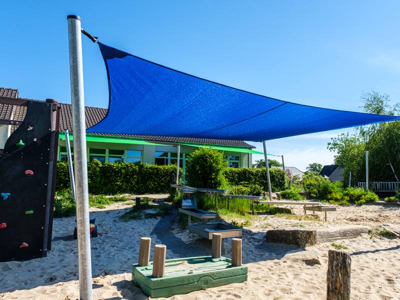 Sonnenschutz für Kita & Kindergarten - blaues Sonnensegel mit Stangen als Spielplatzbeschattung